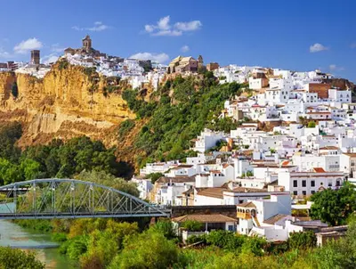 a town on a hill with a bridge and a river at La Cueva del Corregidor in Arcos de la Frontera