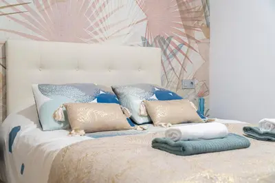 a white bed with pillows and towels on it at Falla Loft & Beach in Cádiz