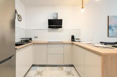 a kitchen with white cabinets and a counter top at Falla Loft & Beach in Cádiz