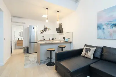 a living room with a couch and a kitchen at Falla Loft & Beach in Cádiz