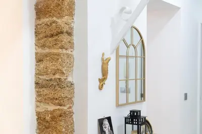 a seahorse hangs on a wall next to a stone column at Falla Loft & Beach in Cádiz