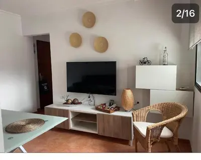 a living room with a tv and a table at Apartamento Reina Mercedes in Chipiona