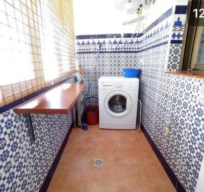 a small bathroom with a washing machine in it at Apartamento Reina Mercedes in Chipiona