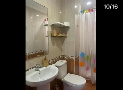 a bathroom with a sink and a toilet and a mirror at Apartamento Reina Mercedes in Chipiona