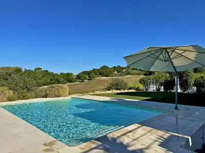 an umbrella sitting next to a swimming pool at Villa Montecastillo - Ole Solutions in Jerez de la Frontera