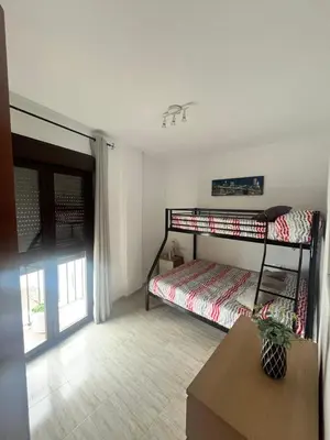 a bedroom with a bunk bed and a table at Cruces in El Puerto de Santa María