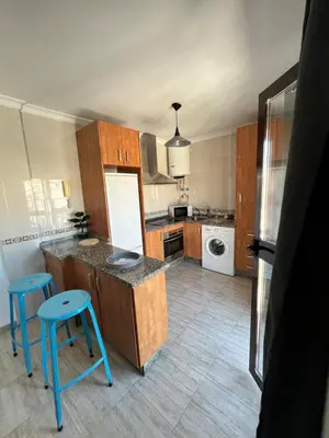 a kitchen with a counter and blue stools in it at Cruces in El Puerto de Santa María