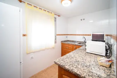a kitchen with a sink and a microwave on a counter at Piso Barrameda in Sanlúcar de Barrameda