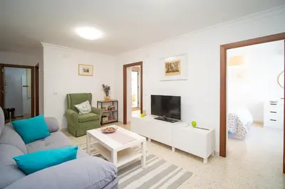a living room with a couch and a tv at Piso Barrameda in Sanlúcar de Barrameda