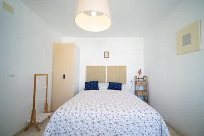 a bedroom with a large bed with blue pillows at Piso Barrameda in Sanlúcar de Barrameda