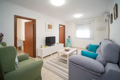 a living room with a couch and chairs and a tv at Piso Barrameda in Sanlúcar de Barrameda