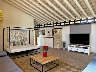 a living room with a large television and a couch at La Bodeguita - Ole Solutions in Jerez de la Frontera