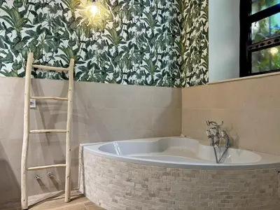 a bath tub in a bathroom with floral wallpaper at La Bodeguita - Ole Solutions in Jerez de la Frontera