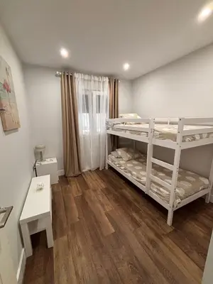 a room with two bunk beds and a table at La caprichosa in Chiclana de la Frontera
