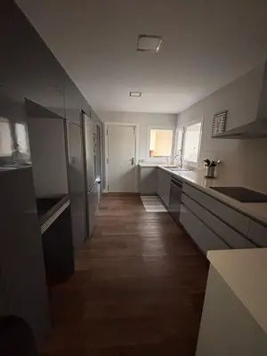 a kitchen with white counters and a long hallway at La caprichosa in Chiclana de la Frontera
