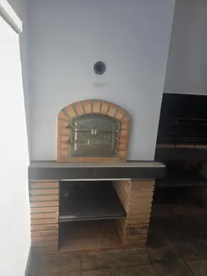 a brick fireplace with a stove in a room at La caprichosa in Chiclana de la Frontera