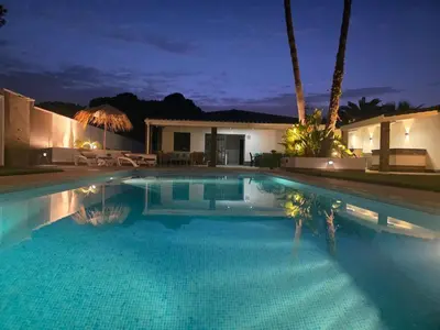 a swimming pool in front of a house at night at La caprichosa in Chiclana de la Frontera