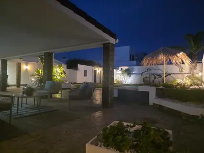 a patio with chairs and tables at night at La caprichosa in Chiclana de la Frontera