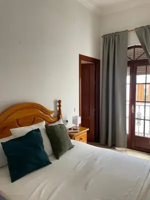 a bedroom with a white bed with green pillows at Espera Apartamentos in Espera