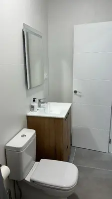 a bathroom with a toilet and a sink and a mirror at Lacana 2 in Chiclana de la Frontera