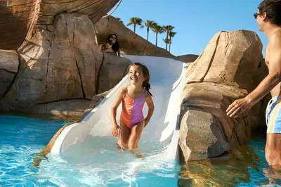a little girl on a slide at a water park at Iberostar Waves Royal Andalus in Chiclana de la Frontera