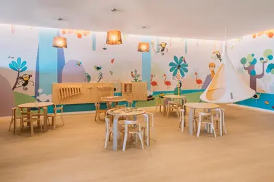 a room with tables and chairs and a wall with a mural at Iberostar Waves Royal Andalus in Chiclana de la Frontera