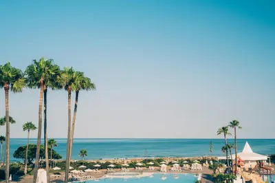 a view of a resort with palm trees and the ocean at Iberostar Waves Royal Andalus in Chiclana de la Frontera