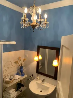 a bathroom with a sink and a mirror and a chandelier at Casa Palacio Jerezana in Jerez de la Frontera