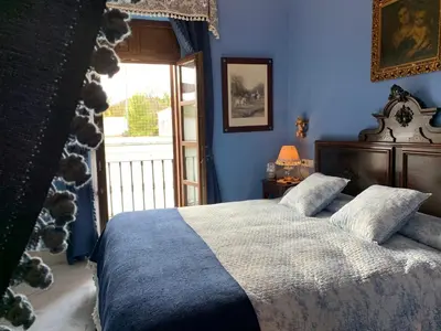 a bedroom with a bed with blue walls and a window at Casa Palacio Jerezana in Jerez de la Frontera