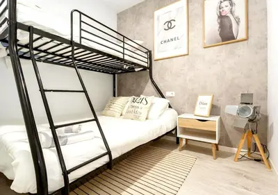 a bedroom with a black bunk bed and a table at precioso piso en playa caleta in Cádiz