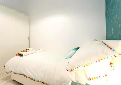 a bedroom with a large white bed with colorful pillows at precioso piso en playa caleta in Cádiz