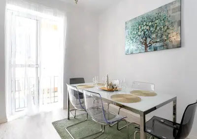 a dining room table with chairs and a painting on the wall at precioso piso en playa caleta in Cádiz