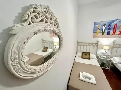 a mirror on a wall in a room with two beds at El Palacito 