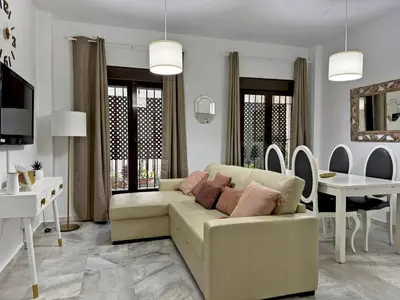 a living room with a couch and a dining room at Apartamento La Frontera - Ole Solutions in Jerez de la Frontera