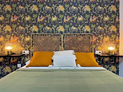 a bedroom with a bed with a patterned wall at Apartamento La Frontera - Ole Solutions in Jerez de la Frontera