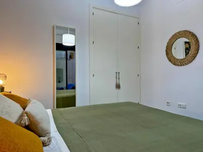 a bedroom with a large bed and a mirror at Apartamento La Frontera - Ole Solutions in Jerez de la Frontera