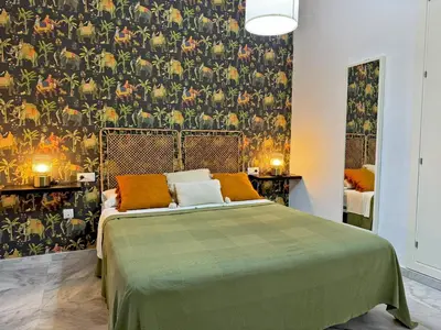 a bedroom with a bed with a green bedspread at Apartamento La Frontera - Ole Solutions in Jerez de la Frontera