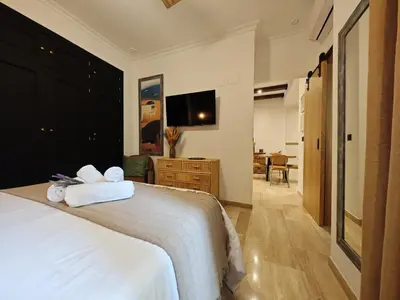 a bedroom with a white bed with towels on it at Le Charme Little Apartments in Cádiz