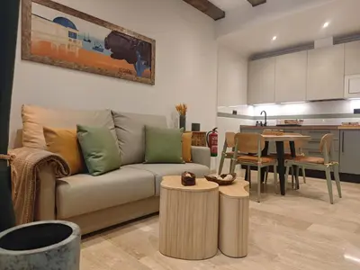 a living room with a couch and a table at Le Charme Little Apartments in Cádiz