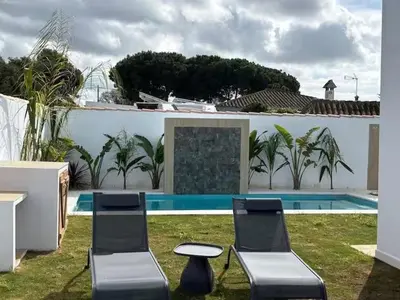 two chairs and a table in front of a pool at GUACA 2 in Cádiz