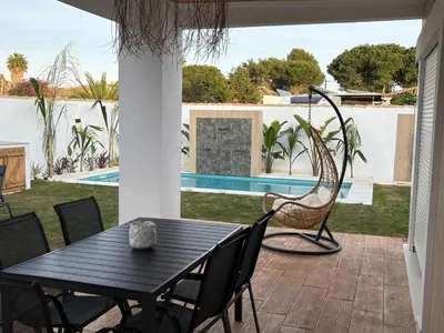 a patio with a table and chairs and a swing at GUACA 2 in Cádiz