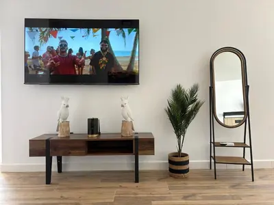 a living room with a table with a tv on the wall at GUACA 2 in Cádiz