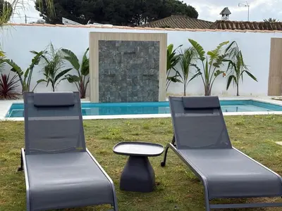 two chairs and a stool in front of a pool at GUACA 2 in Cádiz