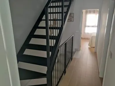 a black spiral staircase in a room with a hallway at Recidencial Cruz del Mar 