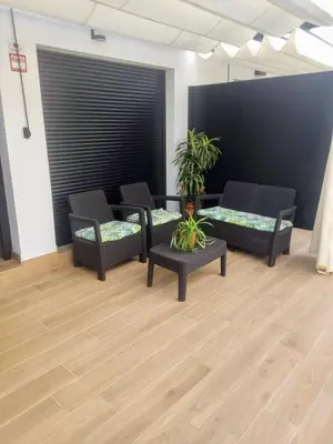 a room with chairs and tables and a black wall at Recidencial Cruz del Mar 