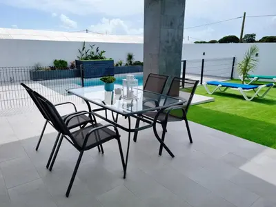 a glass table and chairs on a patio at Casa Calma in Conil de la Frontera