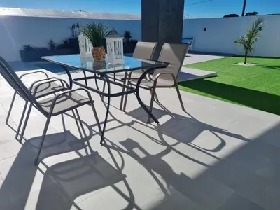 a patio with a glass table and chairs at Casa Calma in Conil de la Frontera