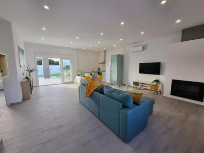 a living room with a blue couch and a tv at Casa Calma in Conil de la Frontera