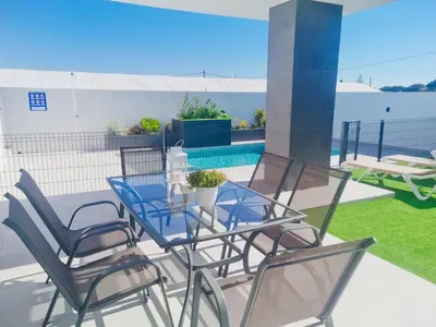 a patio with a table and chairs and a pool at Casa Calma in Conil de la Frontera