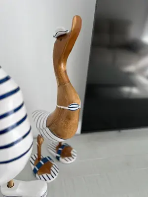a wooden figurine of a bird standing next to a vase at Victoria Centro 34 in Puerto Real